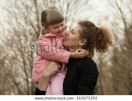 Happy mother and daughter walking outdoors