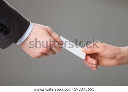 Business people exchanging business card on grey background
