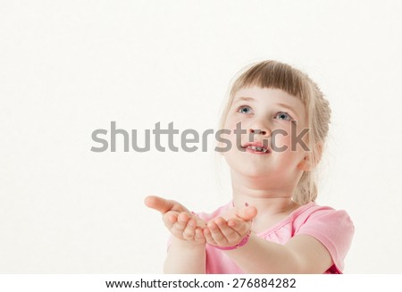 Happy little girl reaching out her palms and catching something, white background