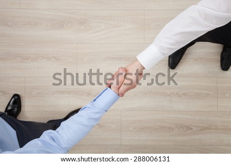 Businessmen shake hands, view from above