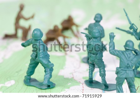 Plastic Army Men Fighting on Topographic Map, throwing granade. The map was produced by the U.S. Geological Survey and is in the public domain.