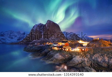 Aurora borealis on the Lofoten islands, Norway. Green northern lights above ocean. Night sky with polar lights. Night winter landscape with aurora and reflection on the water surface. Norway-image
