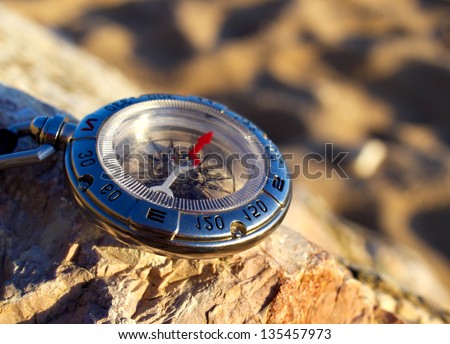 Compass on the beach. Tourist equipment