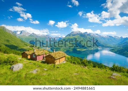 Image, Stock Photo A fjord in Norway. In the foreground the sea and in the background snow-covered mountain tops. The blue sky is decorated by veil clouds.