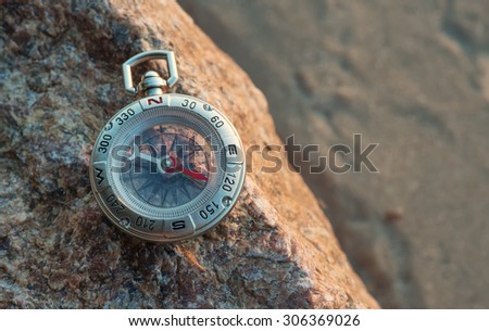 Compass on the beach. Tourist equipment as a background