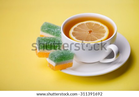 Tea with lemon and fruit jelly. Food and drink as a background