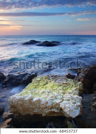 Sea stone and waves during sundown. Natural composition