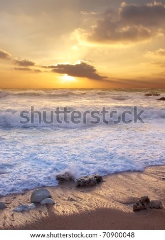 Beach with clean sand and greater wave during bright sundown