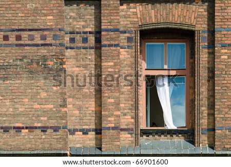 Brick Wall with an Open Window and Curtain