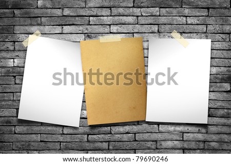 White paper and old paper. Stick tape on the gray brick wall