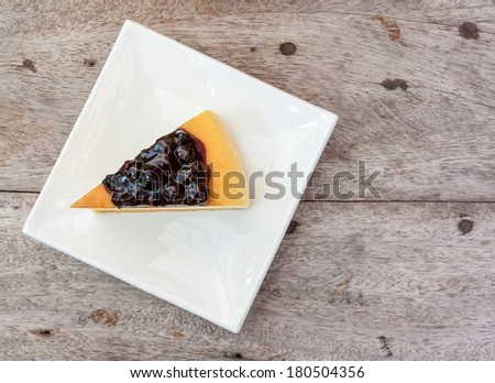 Blueberry cheese cake in white square dish on the wood table.