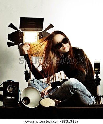 The fashionable girl and photographic equipment