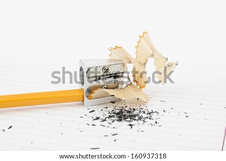 Sharpened pencil next to the sharpener and shavings.
