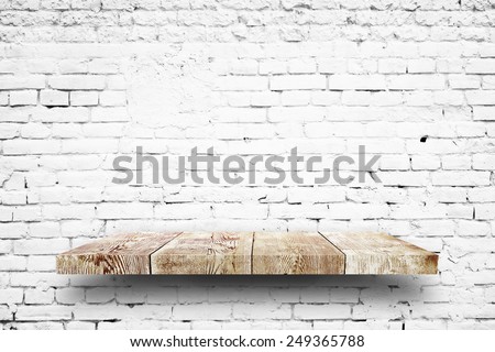 Wooden shelf white brick background