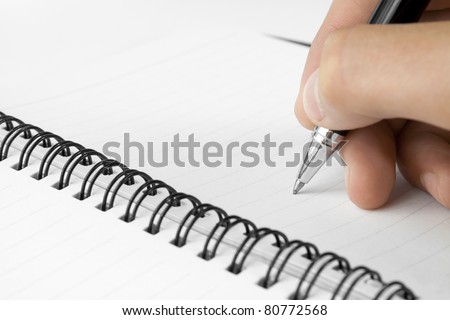 Hand hold a pen writing on the notebook