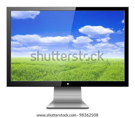 Computer monitor with nature,green field with blue sky. Isolated on white background