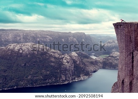 the girl at dawn of the day is doing yoga on the top of the popular mountain Preikestolen Foto stock © 