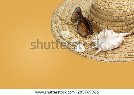 Straw hat, sunglasses and seashells are on the right side of the photo. All is on the yellow background with sand texture. All potential trademarks are removed.