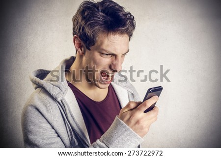 Angry young boy screams to the mobile phone