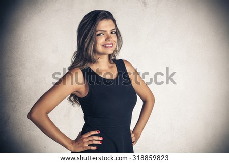 Beautiful young girl holding arms akimbo