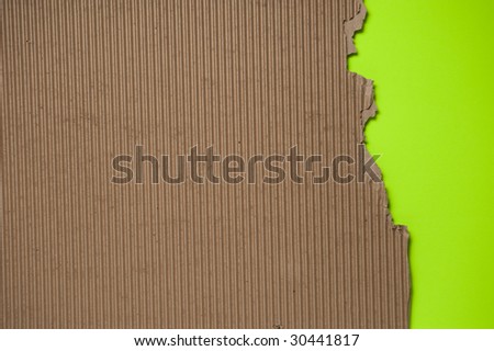 Ripped torn corrugated cardboard textured background with green knock out