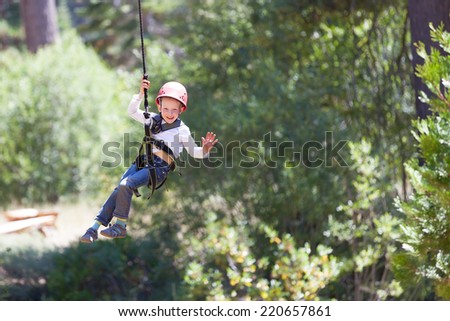 brave little boy ziplining in adventure park