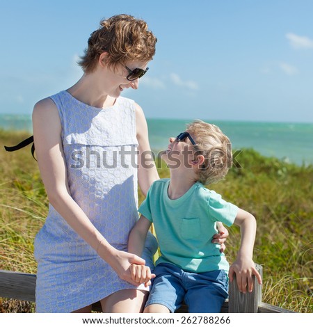 young mother and her kid enjoying mother\'s day at the beach