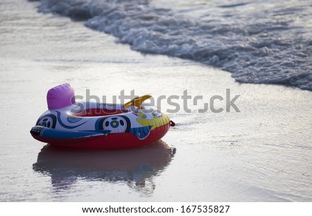 Child\'s inflatable swimming aid on beach at sunset