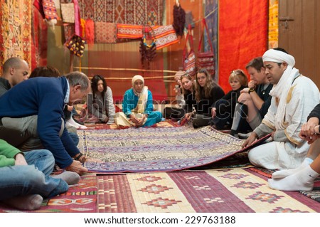 OUARZAZATE, MOROCCO - 25 NOV: Moroccan rug sellers showing traditional berber carpets to visitors. November 25, 2008 in Ouarzazate, Morocco, Africa