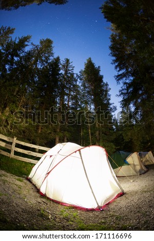 Evening lit tent in camping. Dolomities, Italian Alps, Europe. Concept: nature, vacation, outdoor