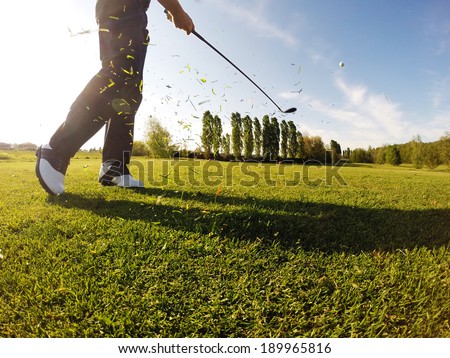 Golfer performs a golf shot from the fairway.