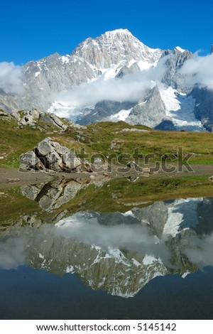 View of the south face of mountain range reflected in a small lake, Italy
