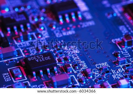 Close-up photo of computer circuit board; blue red tone