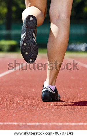 Back of the woman leg while running on the track