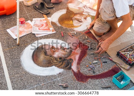 Curtatone, italy 15/08/2015: pavement street artist finishes painting over the asphalt in Madonnari word competition in italy of chalk paintings, from Santuario della Beata Vergine delle Grazie,