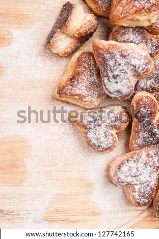 bakery hearts from split pastry with sugar powder on wooden board
