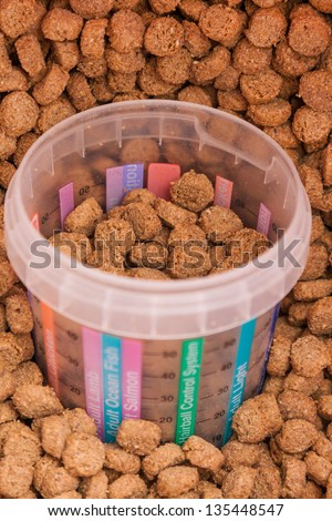 dry brown grained pets food with measured glass