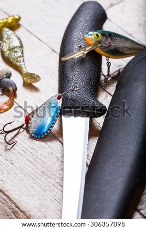 closeup fishing baits and filet knife on white wooden background
