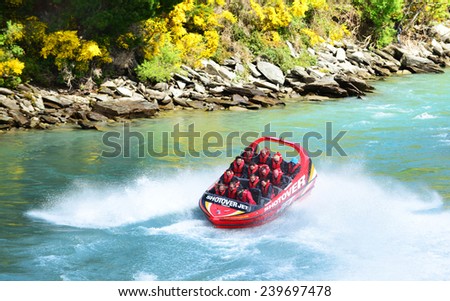 QUEENSTOWN, NEW ZEALAND -  November 18: Tourists enjoy a high-speed boat ride on Queenstown\'s Shotover river on November 18, 2014 in Queenstown, New Zealand. Queenstown is a popular alpine resort