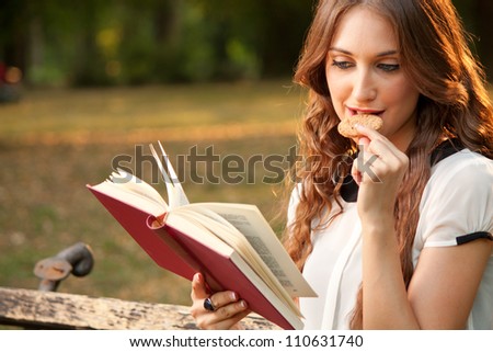 Young woman reading a book in park