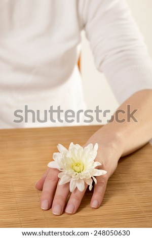 Woman with margarita flower on her hand in a nail salon