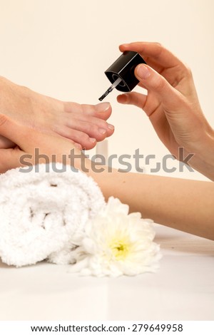 Closeup View Of A Beautician's Hand Applying Nail Varnish To Woman's Feet