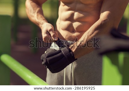 Muscular built young athlete working out in an outdoor gym