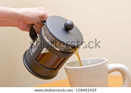 pouring coffee into coffee cup from coffee machine