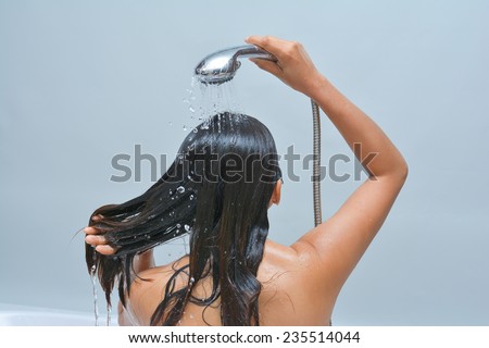 Woman washing her hair with shower, water