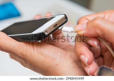 charging battery on mobile phone, hand