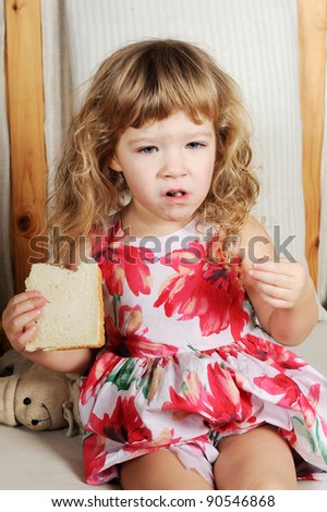 Cute little girl eating white bread