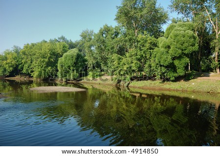 Peaceful scenic view of river and landscape in Summer morning