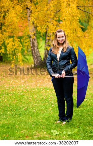Pretty girl in fall park with umbrella