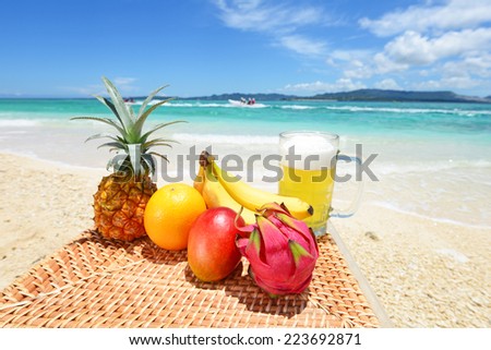 Tropical fruits with beer on the sandy beach